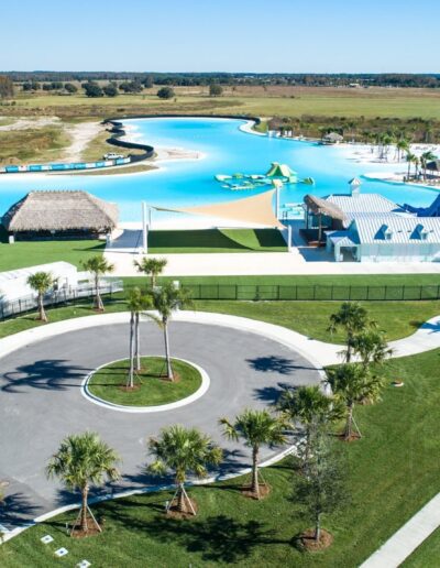 Aerial view of a recreational water park with a large pool, slides, and surrounding facilities.